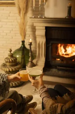 two people holding wine glasses in front of a fireplace at Lale Hotel in Sapanca