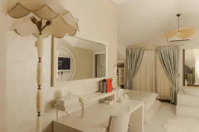 a white bathroom with a sink and a mirror at Lale Hotel in Sapanca
