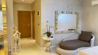 a living room with a chair and a mirror at Lale Hotel in Sapanca
