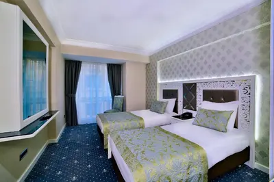 a hotel room with two beds and a television at Monaco Hotel in Istanbul