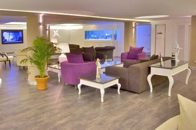 a living room with purple furniture and purple chairs at Monaco Hotel in Istanbul