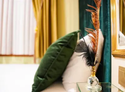a vase with feathers on a table next to a pillow at Grand Moon Hotel Suites in Istanbul