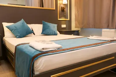 a bed in a room with blue pillows on it at Grand Moon Hotel Suites in Istanbul