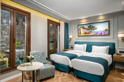 a hotel room with two beds and a chair at Royan Suites in Istanbul