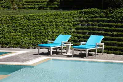 two blue chairs sitting next to a swimming pool at Istanbul Gonen Hotel in Istanbul