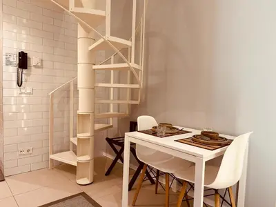 a white dining room with a white table and chairs at Ortakoy Aparts in Istanbul