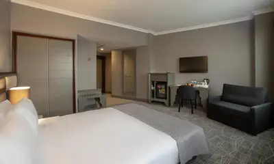 a hotel room with a bed and a chair and a desk at Taksim Square Hotel in Istanbul