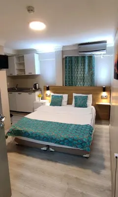 a bedroom with a large bed and a kitchen at Ortaköy Suites Hotel in Istanbul