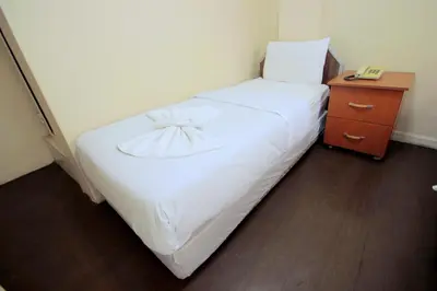 a bedroom with a white bed and a night stand at Istanbul Metro Hotel in Istanbul