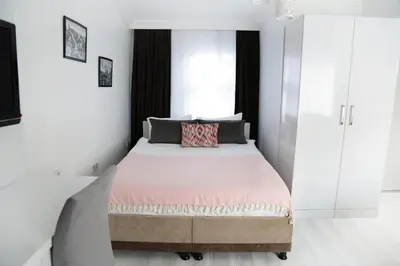 a bedroom with a large bed with white walls at Bayer Hotel in Istanbul