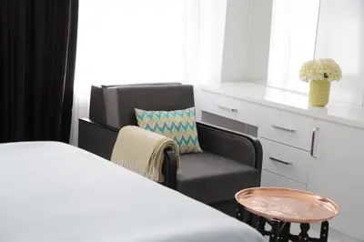 a bedroom with a bed and a chair and a window at Bayer Hotel in Istanbul