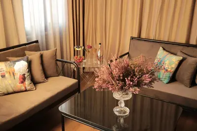 a living room with two couches and a table with flowers at Ferman Pera Hotel in Istanbul