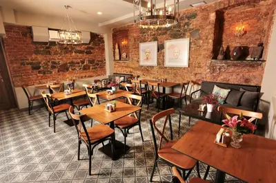 a restaurant with tables and chairs and a brick wall at Ferman Pera Hotel in Istanbul