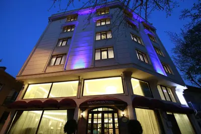 a building with purple lights on top at night at Tuzla Garden Hotel & Spa in Tuzla
