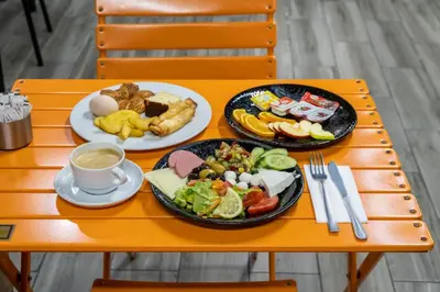 a orange table with plates of food and a cup of coffee at The Queen Hotel in Istanbul
