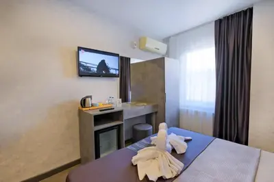 a hotel room with a bed and a tv on the wall at The Queen Hotel in Istanbul