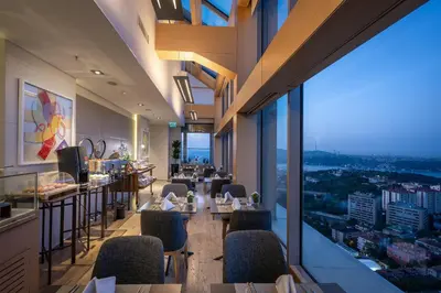 a restaurant with tables and chairs and a view of a city at Renaissance Istanbul Polat Bosphorus Hotel in Istanbul
