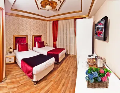 a hotel room with two beds and a television at Marmara Deluxe Hotel in Istanbul