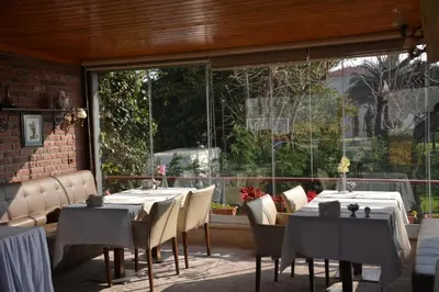 a restaurant with tables and chairs and a large window at Dilhayat Kalfa Hotel in Istanbul
