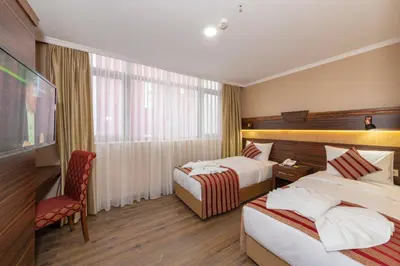 a hotel room with two beds and a chair at Vision Deluxe Hotel in Istanbul