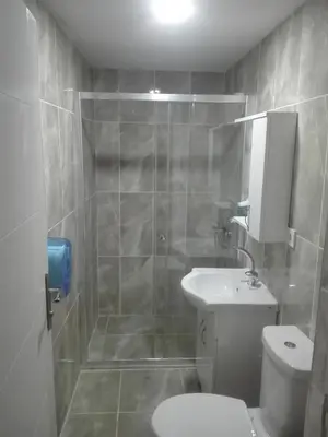 a bathroom with a shower and a toilet and a sink at NEW BEYLERBEYİ HOTEL in Istanbul