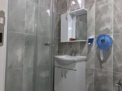 a bathroom with a shower with a sink and a mirror at NEW BEYLERBEYİ HOTEL in Istanbul