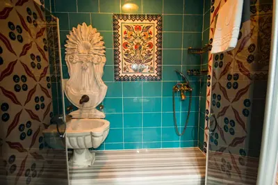 a blue tiled bathroom with a toilet and a shower at Sultan Corner Hotel in Istanbul