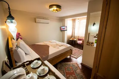 a bedroom with a bed and a table with dishes on it at Sultan Corner Hotel in Istanbul