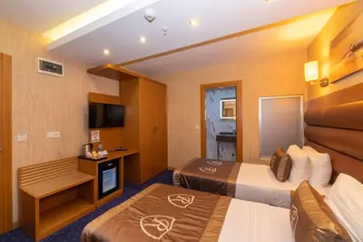 a hotel room with two beds and a television at Regno Hotel in Istanbul