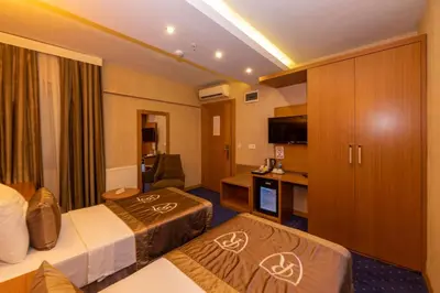 a hotel room with two beds and a television at Regno Hotel in Istanbul