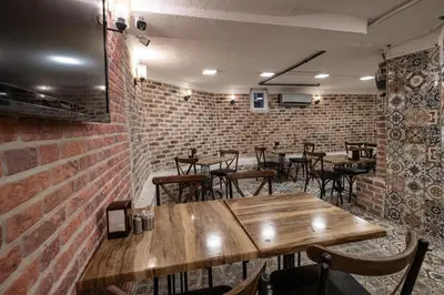 a restaurant with wooden tables and chairs and brick walls at Family Istanbul Hotel in Istanbul