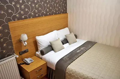 a bedroom with a bed with a phone next to it at Abel Hotel in Istanbul
