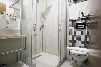 a bathroom with a shower and a toilet and a sink at NL Amsterdam Hotel in Istanbul