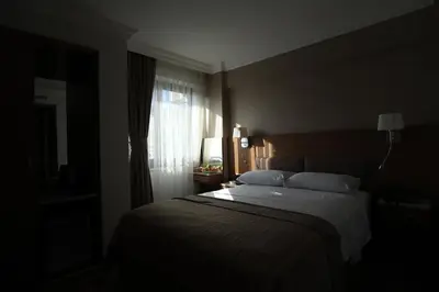 a bedroom with a bed in a dark room at NL Amsterdam Hotel in Istanbul