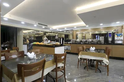 a restaurant with a table and chairs and a kitchen at NL Amsterdam Hotel in Istanbul