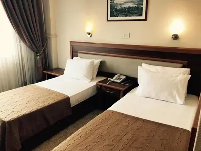 a hotel room with two beds and a telephone at Hotel Villa Marina in Bandırma