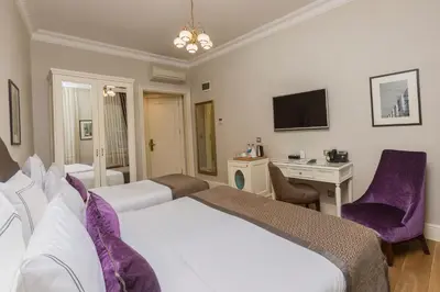 a hotel room with two beds and a desk at Meroddi Galata Mansion in Istanbul