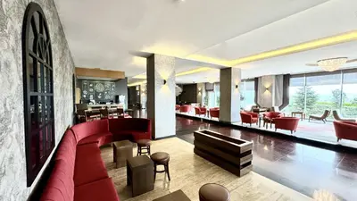 a hotel lobby with a red couch and chairs at Ramada by Wyndham Tekirdağ in Tekirdag