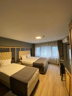 a hotel room with two beds and a television at Ortakoy Aysem Sultan Hotel in Istanbul
