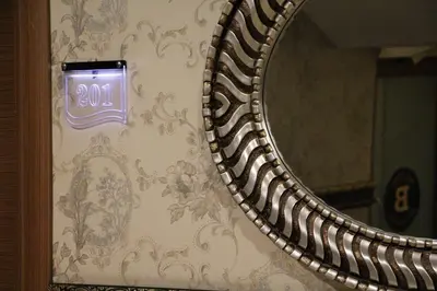 a mirror with a clock on a wall at Balturk House Hotel in Kocaeli