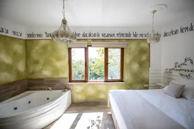 a bedroom with a tub and a bed and a window at Beyaz Ev Agva - Adult only +15 in Agva