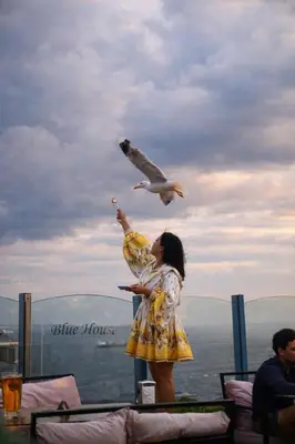 a woman in a yellow dress flying a bird at Blue House Hotel Old City - Sultanahmet in Istanbul