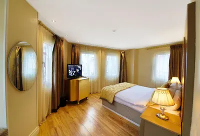 a bedroom with a bed and a television and windows at Katelya Hotel in Istanbul