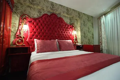 a red bed with a red headboard in a bedroom at Katelya Hotel in Istanbul