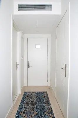 a hallway with a white door and a rug at KRALICE HOTEL in Istanbul