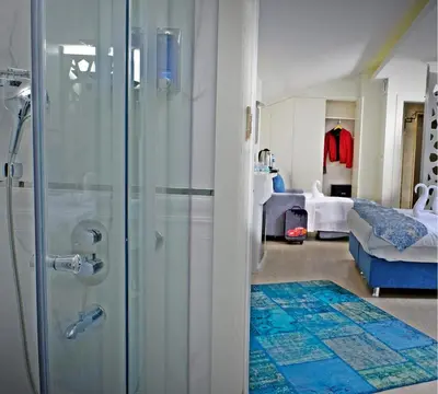 a bathroom with a shower and a bedroom at KRALICE HOTEL in Istanbul