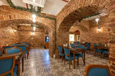 a restaurant with brick walls and tables and blue chairs at Meserret Palace Hotel - Special Category in Istanbul