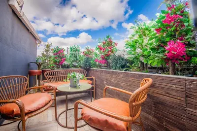 a patio with chairs and tables and pink flowers at Lord Morgan & Exclusive Design Residence Cihangir in Istanbul
