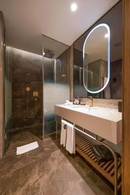 a bathroom with a sink and a shower with a mirror at Radisson Collection Hotel, Vadistanbul in Istanbul