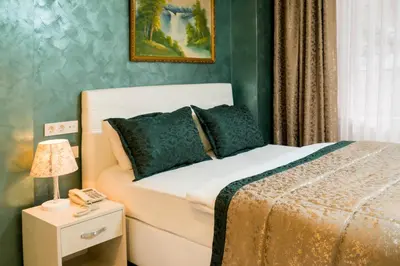 a bedroom with a bed and a table with a lamp at ATAM HOTEL in Istanbul